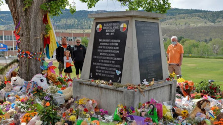 People visit a makeshift memorial on the grounds of the former Kamloops Indian Residential School, after the Tk'emlups te Secwepemc band council encouraged mourners to take part in a national day of prayer to honor the remains of 215 children that were found at the site in Kamloops, British Columbia, Canada June 6, 2021. REUTERS/Jennifer Gauthier/File Photo



