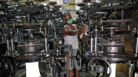 A worker wearing a protective face mask cleans a machine inside an undergarment factory after it was re-opened after a weeks-long shutdown to slow the spread of coronavirus disease (Covid-19), in Kolkata. Photo: Reuters