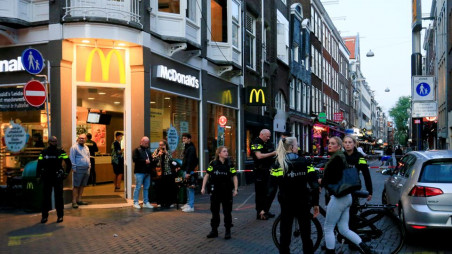 People look on as police officers secure the area where Dutch celebrity crime reporter Peter R. de Vries, known for his reporting on some of the most renowned criminals in the Netherlands, was reportedly shot and seriously injured, in Amsterdam, Netherlands, July 6, 2021. REUTERS/Eva Plevier