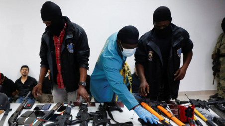Weaponry, mobile phones, passports and other items are being shown to the media along with suspects in the assassination of President Jovenel Moise, who was shot dead early Wednesday at his home, in Port-au-Prince, Haiti July 8, 2021. REUTERS/Estailove St-Val