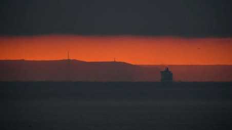 A cross channel ferry is seen in the English Channel with the coast of France seen behind at dawn on the first day following the end of the Brexit transition period, seen from Dover, Britain, January 1, 2021. REUTERS