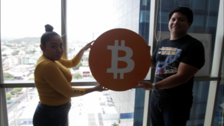 Juan Mayen, 28, chief executive of Honduran firm TGU Consulting Group, and Claudia Suazo pose for a photo holding a Bitcoin logo at the office of TGU where they installed the first cryptocurrency ATM machine in the country that allows users to acquire bitcoin and ethereum using the local lempira currency, in Tegucigalpa, Honduras August 27, 2021. REUTERS/Fredy Rodriguez








