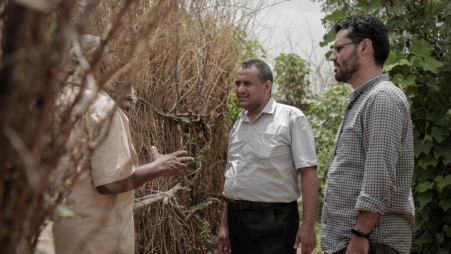 Ameen Jubran (centre), head and co-founder of Jeel Albena, talks to a displaced man at a camp near Hudaydah, Yemen.  Photo: UNHCR