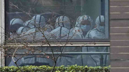 Members of a World Health Organization team are seen through a window wearing protective gear during a field visit to the Hubei Animal Disease Control and Prevention Center for another day of field visit in Wuhan in central China's Hubei province, on Feb. 2, 2021. Nearly two years into the COVID-19 pandemic, the origin of the virus tormenting the world remains shrouded in mystery. Photo: UNB/AP