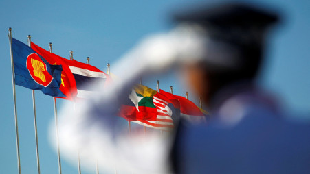 A police officer stands near national flags of ASEAN counties flags during the 25th ASEAN Summit in Myanmar International Convention Centre in Naypyitaw November 12, 2014. Photo :Reuters