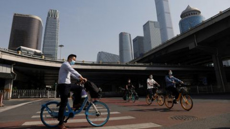 People ride shared bicycles during morning rush hour at the Central Business District (CBD), following a work-from-home order for residents of Chaoyang district amid the coronavirus disease (Covid-19) outbreak, in Beijing, China May 5, 2022. REUTERS/Tingshu Wang