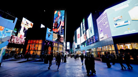 People walk beneath advertisements at Boulevard entertainment city in Riyadh.Photographer: Fayez Nureldine/AFP/Getty Images/Bloomberg
