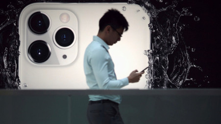 A man walks next to an advertisement for Apple's new iPhone 11 Pro at the Apple Store in IFC, Central district, Hong Kong, China October 10, 2019, after Apple Inc on Wednesday removed an app that protestors in Hong Kong have used to track police movements from its app store. REUTERS/Athit Perawongmetha/File Photo
