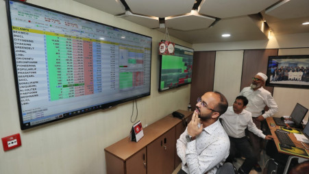 People look at stock market data. File Photo: TBS