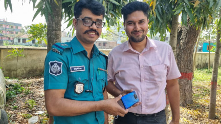 SI Milton Kumar Deb Das hands over a recovered phone to its owner. Photo: Courtesy