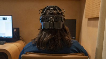 Emily Hollenbeck, a deep brain stimulation therapy patient, demonstrates an EEG device that records brain activity as she reacts to short videos at Mount Sinai’s “Q-Lab” in New York on 20 December, 2023. AP Photo/Mary Conlon