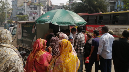 People gather in front of a government truck selling food essentials a lower price in Merul Badda on 12 March 2024. Photo: TBS