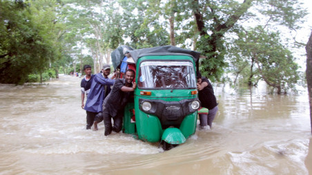 People trying to move a CNG during the flood. Photos: Courtesy 