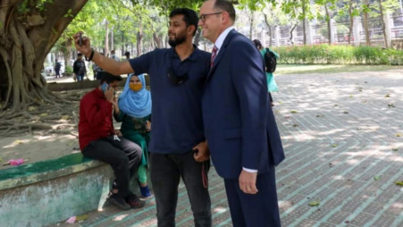 A student taking a picture with US Ambassador to Bangladesh Peter Haas at the Dhaka University campus. Photo: UNB