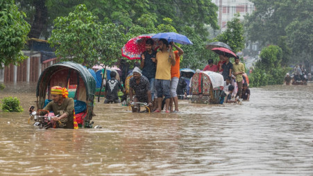 Heavy rainfall in Azimpur leaves city dwellers wading through waist-deep water on rickshaws and vans on Friday. Parts of Dhaka were submerged after 130mm of rain fell in just 6 hours. Photo: Rajib Dhar/TBS