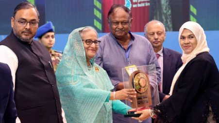 Prime Minister Sheikh Hasina hands over one of the 77 exporters with the National Export Trophy during a ceremony in the city’s Osmani Memorial Auditorium in Dhaka on Sunday, 14 July. Photo: UNB via PMO