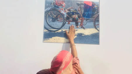 Martyred Golam Nafiz’s mother standing in front of a picture where he was seen being carried on a rickshaw after being shot on 4 August. Photo: Facebook