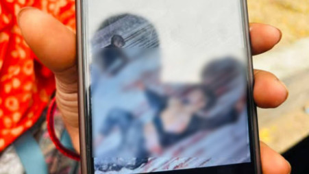 Akila Begum shows a picture of her brother Md Jumman's dead body taken after a shootout with joint forces in Mohammadpur in the early hours of 20 February. Photo: TBS