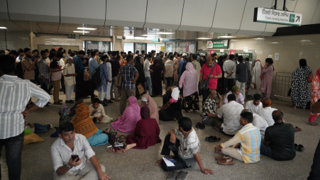 Commuters sit on the floor at Shahbagh metro station amid an increased crowd on 22 May 2025. Photo: Sadiqe Al Ashfaqe/TBS