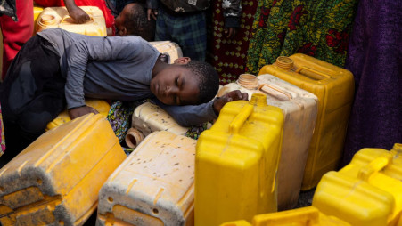 A child sleeps on plastic jerrycans as people queue at the standpipe, where incomplete water connections caused by USAID funding cuts to the NGO Mercy Corps have led to ongoing water shortages, in Goma, North Kivu province, Democratic Republic of Congo, June 16, 2025. Photo: REUTERS/Arlette Bashizi/File Photo