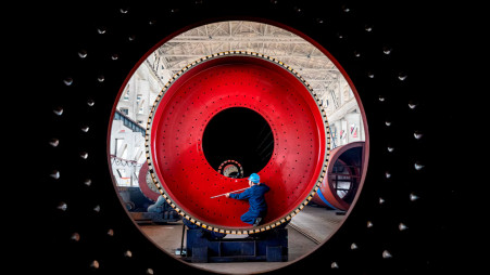 An employee measures a newly manufactured ball mill machine at a factory in Nantong, Jiangsu province, China June 28, 2019. Photo: REUTERS