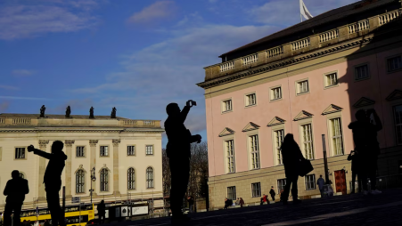 Tourists take photographs in front of the Humboldt University (L) and the German State Opera House in Berlin, Germany, on 3 December 2018. Photo: REUTERS
