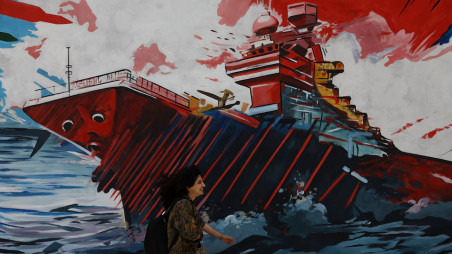 An Iranian woman walks next to a mural on a street in Tehran, Iran, May 6, 2026. Majid Asgaripour/WANA (West Asia News Agency) via REUTERS