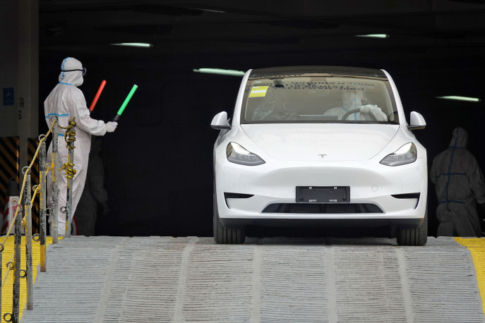 A driver in PPE moves a new Shanghai Tesla passenger car from a ro-ro ship in the port of Yantai on April 25.  Photographer: Tang Ke/Future Publishing/Getty Images/Bloomberg