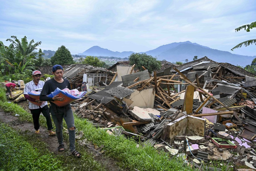 Villagers walk past damaged houses in Cianjur, West Java, Indonesia, Nov. 26, 2022. (Xinhua/Zulkarnain)

