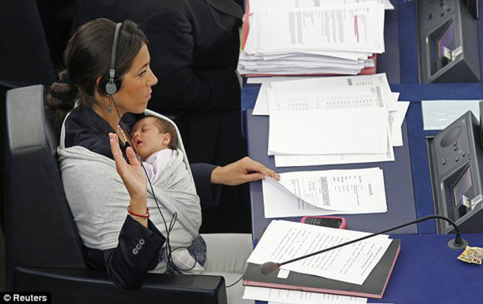 Italian politician Licia Ronzulli's little baby sleeps peacefully in a sling tied around his mother's shoulders in the European Parliament.  Photo: Reuters