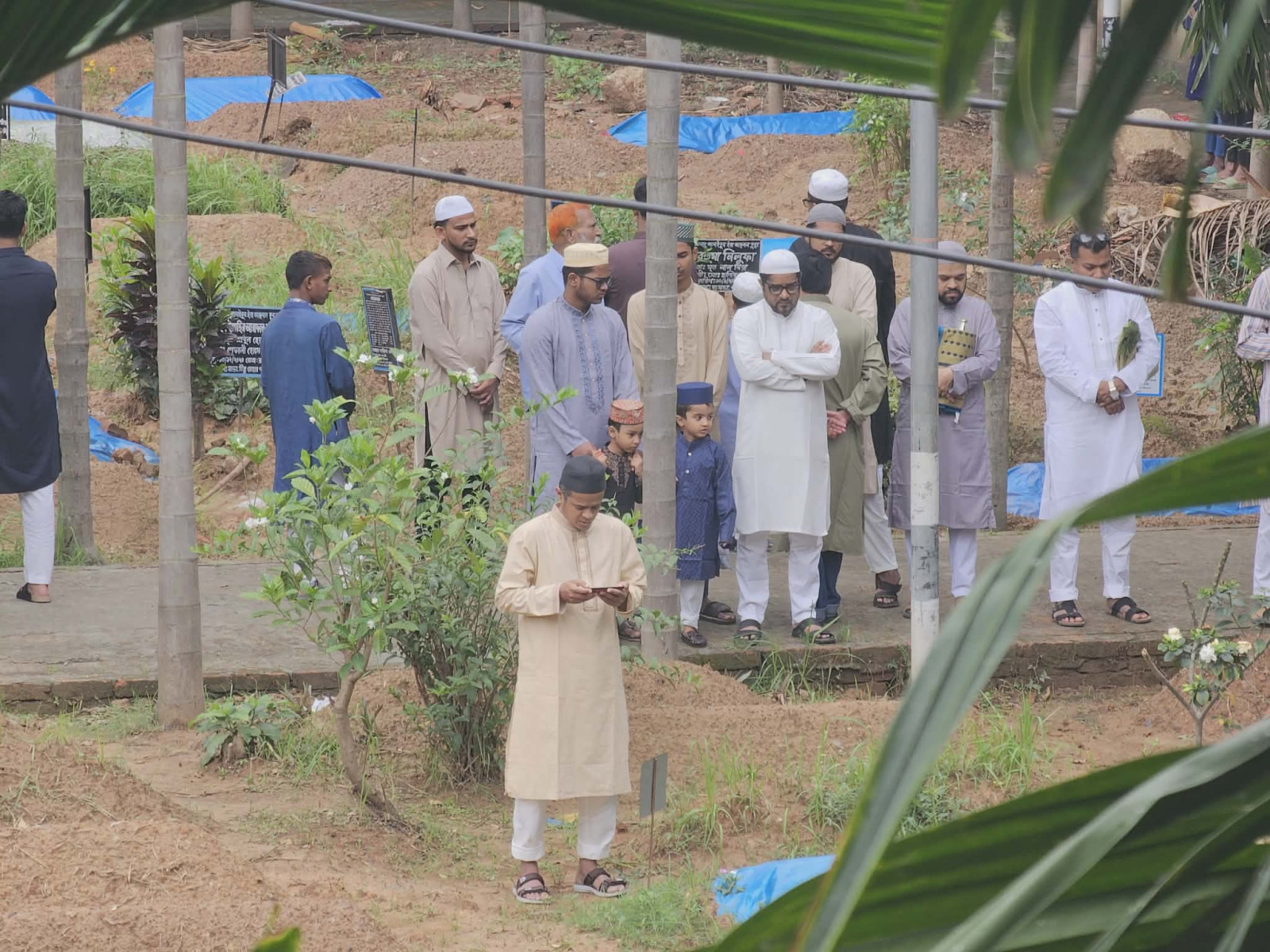 People offer prayers at graves for their loved ones, marking Eid, in Mugda graveyard, Dhaka, on 21 March 2026. Photo: Tashahud Ahamed Rafim