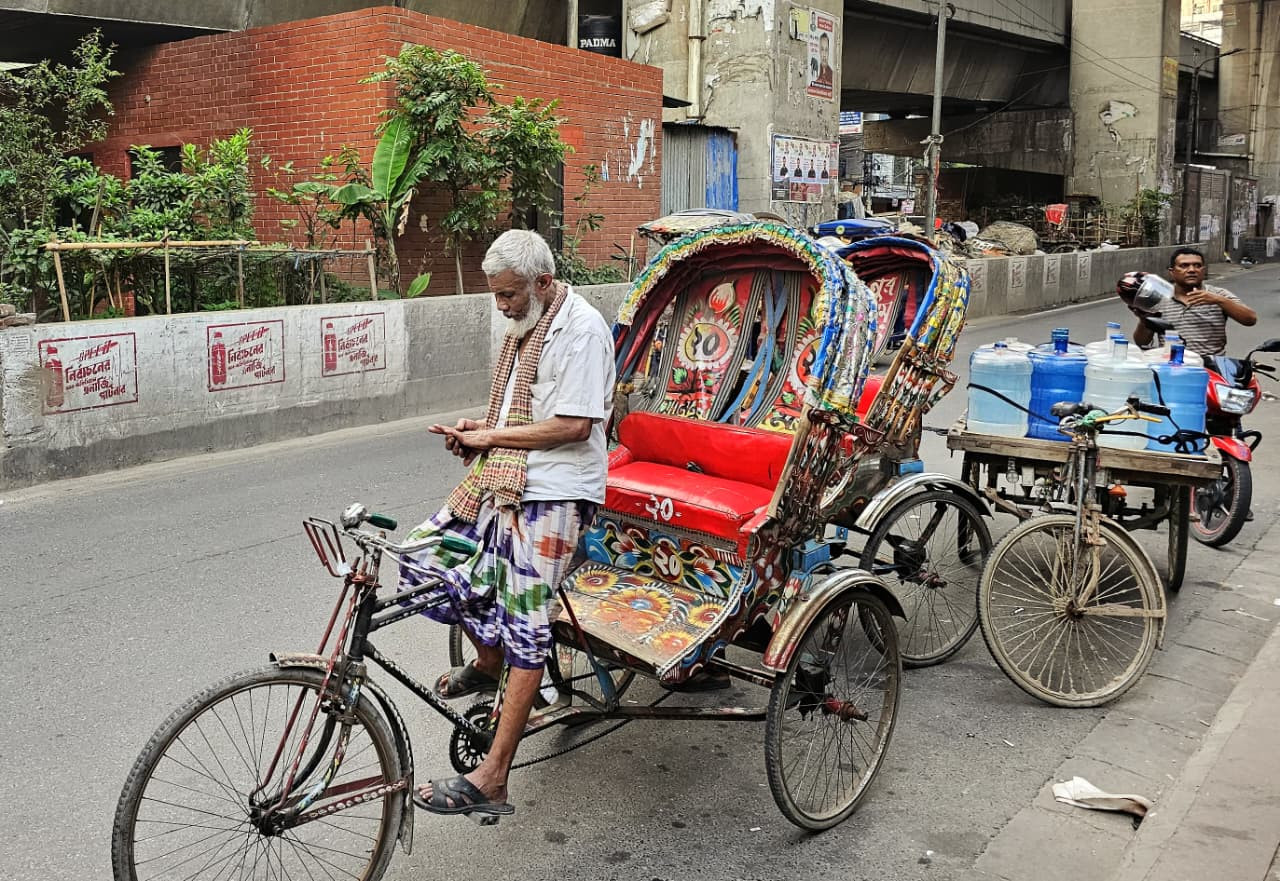 Salamat, who has been pulling a rickshaw on Dhaka’s streets for the past 17 years, pauses beside his vehicle during a workday in the capital. Photo: Tashahud Ahamed Rafim/TBS 