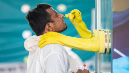 A health worker inside a kiosk is collecting nasal swab from a potential patient. File Photo: Mumit M/TBS