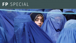 A girl looks on among Afghan women lining up to receive relief assistance. Photo: Reuters