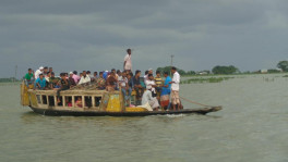 A boat in the River Dhanu in Khaliajuri upazila of Netrokona ferries people and motorbikes. Located in a vast haor area, the remote upazila remains inundated for at least six months a year when boats are the only means of communication for locals to move from one place to another. Photo: TBS
