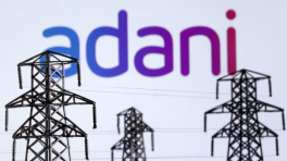 Electric power transmission pylon miniatures and Adani Green Energy logo are seen in this illustration taken, on 9 December 2022. Photo: Reuters
