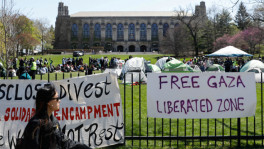 Signs are displayed in front of Deering Meadow, where an encampment of students are protesting in support of Palestinians, during the ongoing conflict between Israel and the Palestinian Islamist group Hamas, at Northwestern University campus in Evanston, Illinois, U.S., April 25, 2024. REUTERS/Nate Swanson