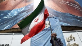 A man holds an Iranian flag near an anti-US billboard depicting US President Donald Trump and the Strait of Hormuz, in Tehran, Iran, May 30, 2026. Photo: Majid Asgaripour/WANA (West Asia News Agency) via REUTERS