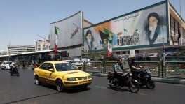 People ride past a mural depicting the late leader of the Islamic Revolution, Ayatollah Ruhollah Khomeini, and the late Iran's Supreme Leader Ayatollah Ali Khamenei, on a street in Tehran, Iran, June 9, 2026. Photo: Majid Asgaripour/WANA (West Asia News Agency) via REUTERS